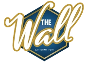 Hexagonal logo with the text "THE Wall" in gold cursive on a blue background, accompanied by the mention "Live Game Show"