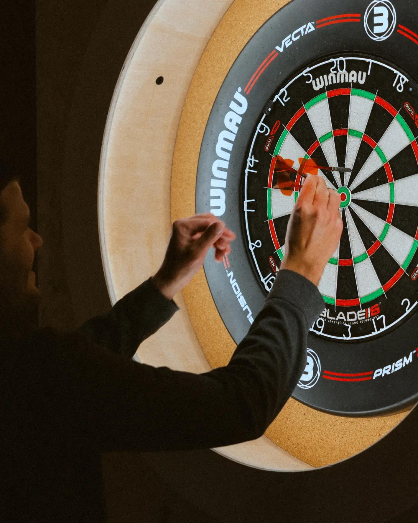 A person throws a dart at a dartboard.